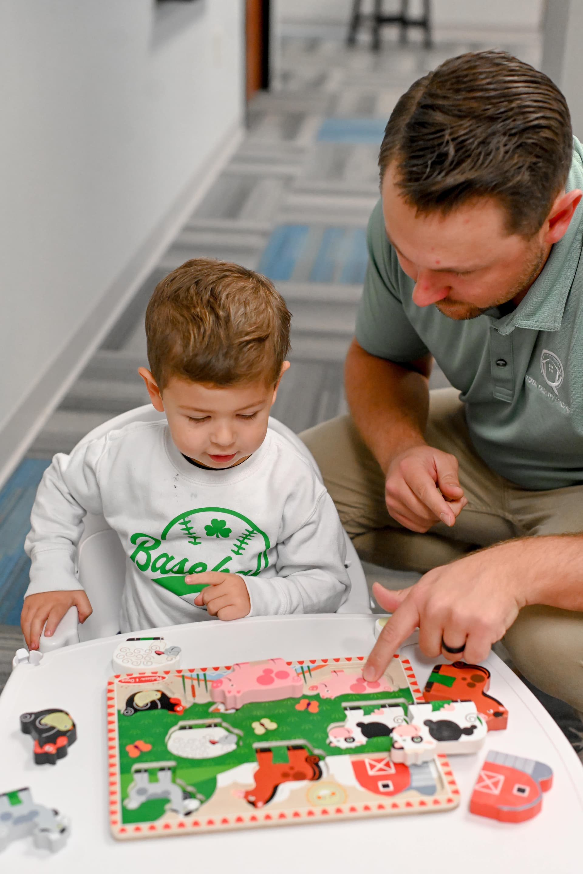 Father and son sitting together at home, working through a puzzle — Total Quality Lending family-first approach